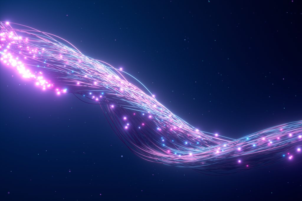 A swirling stream of glowing light trails in shades of pink, purple, and blue unfolds across a dark background, evoking the dynamic energy flow of managed spectrum in futuristic technology.