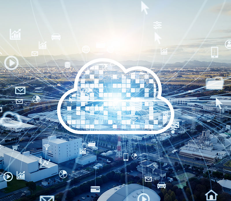 A digital cloud icon overlays an aerial view of a city, surrounded by technology and communication icons, symbolizing cloud computing and data connectivity.